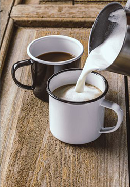 Zwei Emaille Tassen gefüllt mit Milchkaffee